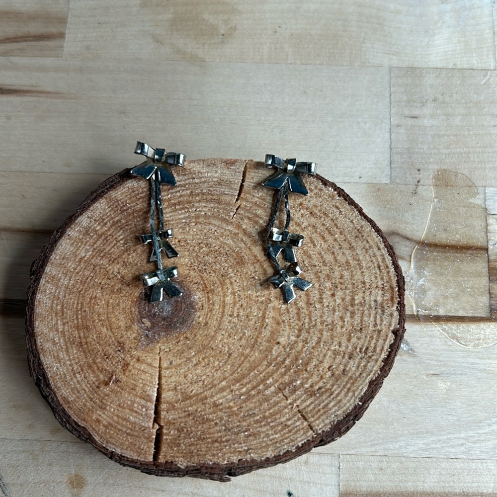 Silver earrings dangling bows